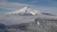 Mount Hood behind low clouds and snowy forest in the Cascade Range, Oregon Aerial Stock Photos | AX154_112.0000000F