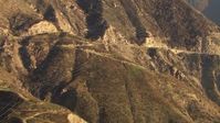 HD stock footage aerial video track power lines crossing a road and up a slope in the San Gabriel Mountains, California Aerial Stock Footage | AF0001_000478