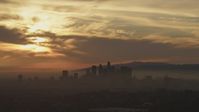 5K stock footage aerial video of a view of sunset and clouds above the hazy Downtown Los Angeles skyline, California Aerial Stock Footage | AF0001_000988