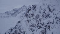 4K stock footage aerial video fly over summit toward a snow covered range, Chugach Mountains, Alaska, sunset Aerial Stock Footage | AK0001_0188