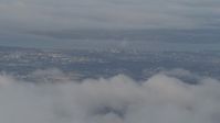 4K stock footage aerial video flying over snowy ridge, low clouds, reveal Anchorage, Chugach Mountains, Alaska Aerial Stock Footage | AK0001_0566