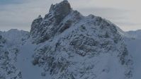 4K stock footage aerial video ascend snowy slope, approach rocky, snow-covered Chugach Mountains, Alaska Aerial Stock Footage | AK0001_0824