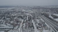 4K stock footage aerial video following Glenn Highway, revealing Downtown Anchorage, Alaska in snow Aerial Stock Footage | AK0001_1516