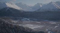 4K stock footage aerial video wooded slopes and river valley, tilt up to snow capped Chugach Mountains, Alaska Aerial Stock Footage | AK0001_1766