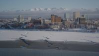 4K stock footage aerial video tilt up from surface of Cook Inlet revealing snowy Downtown Anchorage, Alaska Aerial Stock Footage | AK0001_2023