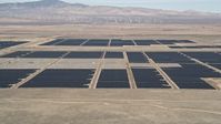 5K stock footage aerial video fly low over desert hill and reveal solar array in Antelope Valley, California Aerial Stock Footage | AX0005_102