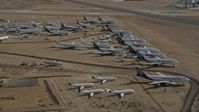 5K stock footage aerial video orbit a group of aircraft at a boneyard in the Mojave Desert, California Aerial Stock Footage | AX0006_064E