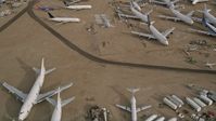 5K stock footage aerial video fly over several jet airplanes at an aircraft boneyard in the Mojave Desert, California Aerial Stock Footage | AX0006_079E