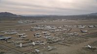 5K stock footage aerial video circle over planes at an aircraft boneyard in the Mojave Desert, California Aerial Stock Footage | AX0006_082E