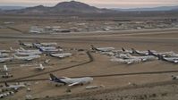 5K stock footage aerial video orbit several aircraft at a boneyard by a small airport in the desert, Mojave Air and Space Port, California Aerial Stock Footage | AX0006_085