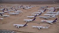 5K stock footage aerial video orbit several rows of cargo planes in an aircraft boneyard at Sunset, Victorville Airport, California Aerial Stock Footage | AX0007_009
