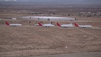 5K stock footage aerial video approach group of airliners at Sunset in an aircraft boneyard, Victorville Airport, California Aerial Stock Footage | AX0007_012