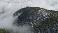 5K stock footage aerial video orbit clouds surrounding mountains with snow in the San Jacinto Mountains, California Aerial Stock Footage | AX0010_071