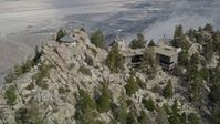 5K stock footage aerial video orbit a rocky summit to reveal the Palm Springs Tramway in the San Jacinto Mountains, California Aerial Stock Footage | AX0010_106E