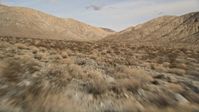 5K stock footage aerial video of low altitude fly over of desert plants toward mountains in Joshua Tree National Park, California Aerial Stock Footage | AX0011_016