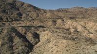 5K stock footage aerial video approach a mountain peak revealing a highway, San Jacinto Mountains, California Aerial Stock Footage | AX0014_002