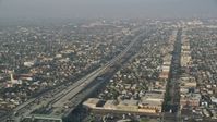 5K stock footage aerial video of Interstate 110 with traffic, tilt to reveal neighborhoods, South Central Los Angeles Aerial Stock Footage | AX0017_039