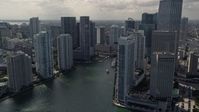 5K stock footage aerial video tilt from fishing boats in the bay to reveal skyscrapers and river in Downtown Miami, Florida Aerial Stock Footage | AX0020_026E
