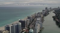 5K stock footage aerial video tilt from Indian Creek Drive to row of oceanfront condominiums in Miami Beach, Florida Aerial Stock Footage | AX0021_024