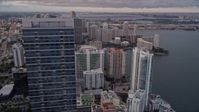 5K stock footage aerial video orbit top of Four Seasons Hotel to reveal waterfront skyscrapers in Downtown Miami at sunset, Florida Aerial Stock Footage | AX0022_043