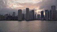 5K stock footage aerial video of Downtown Miami coastal skyline at sunset, approach Miami River, Florida Aerial Stock Footage | AX0022_061E