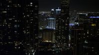 5K stock footage aerial video tilt from bridge to reveal and approach skyscrapers in Downtown Miami at night, Florida Aerial Stock Footage | AX0023_037E