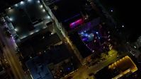 5K stock footage aerial video bird's eye view of a South Beach hotel with bright lights at nighttime, Florida Aerial Stock Footage | AX0023_116