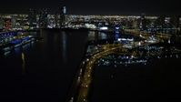5K stock footage aerial video tilt from the MacArthur Causeway to reveal skyscrapers in Downtown Miami at night in Florida Aerial Stock Footage | AX0023_135