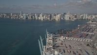 5K stock footage aerial video fly over cranes, cargo containers, Port of Miami, reveal Downtown Miami, Florida Aerial Stock Footage | AX0024_115E