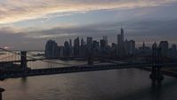 5K stock footage aerial video fly over Manhattan Bridge, approach the Brooklyn Bridge and Lower Manhattan skyline, New York City, winter, twilight Aerial Stock Footage | AX0065_0175E