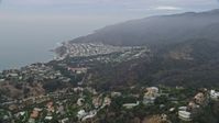 7.6K stock footage aerial video flying over hillside mansions to approach a coastal neighborhood in the morning, Pacific Palisades, California Aerial Stock Footage | AX0156_162