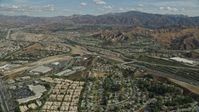 7.6K stock footage aerial video flying over suburban housing toward highway and mountains, Santa Clarita, California Aerial Stock Footage | AX0159_050