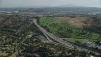 7.6K stock footage aerial video flying over homes to approach I-10 and Forest Lawn Covina Hills Cemetery in Covina, California Aerial Stock Footage | AX0159_130
