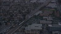 7.6K stock footage aerial video of a Metrolink commuter train passing neighborhoods at twilight in Burbank, California  Aerial Stock Footage | AX0162_113