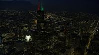 4K stock footage aerial video of flying by Willis Tower with holiday lights at night, Downtown Chicago, Illinois Aerial Stock Footage | AX0170_0070