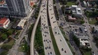 6.7K stock footage aerial video tilt from heavy traffic on I-95, reveal tall skyscrapers in Downtown Miami, Florida Aerial Stock Footage | AX0172_112