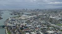 6K stock footage aerial video of approaching warehouses with view of Downtown Oakland skyline, California Aerial Stock Footage | AX0173_0002