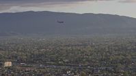 6K stock footage aerial video of a commercial airplane flying over San Jose at sunset, California Aerial Stock Footage | AX0174_0030