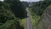 4.8K stock footage aerial video Following traffic along a highway through lush green mountains, Karst Forest, Puerto Rico Aerial Stock Footage | AX101_081