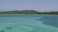 4.8K stock footage aerial video Flying over crystal clear blue water toward forest and Cape San Juan Light, Puerto Rico Aerial Stock Footage | AX102_060