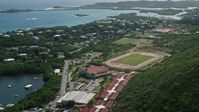 4.8K stock footage aerial video of a High school track field near blue coastal waters, East End, St Thomas Aerial Stock Footage | AX102_244