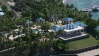 4.8K stock footage aerial video of an Oceanfront mansion and palm trees on turquoise blue waters, Little St James Island, St Thomas Aerial Stock Footage | AX102_253