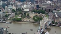 5.5K stock footage aerial video of Tower Bridge and Tower of London along the River Thames, London, England Aerial Stock Footage | AX114_096