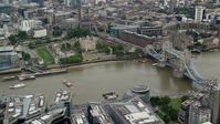 5.5K stock footage aerial video of passing the Tower of London and Tower Bridge over the River Thames, England Aerial Stock Footage | AX114_120
