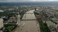 5.5K stock footage aerial video of bridges spanning the River Thames between London Eye and Parliament, England Aerial Stock Footage | AX115_121