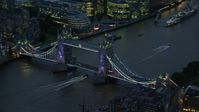 5.5K stock footage aerial video of flying by Tower Bridge spanning River Thames in London, England, night Aerial Stock Footage | AX116_160