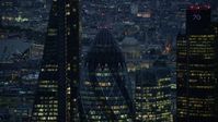 5.5K stock footage aerial video of orbiting the top of The Gherkin skyscraper in London, England, night Aerial Stock Footage | AX116_163