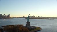 5.5K stock footage aerial video of flying away from the Statue of Liberty at sunrise in New York Aerial Stock Footage | AX118_118