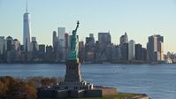 5.5K stock footage aerial video approach the Statue of Liberty at sunrise in New York, and flyby for a view of Lower Manhattan skyline Aerial Stock Footage | AX118_131E