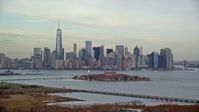 5.5K stock footage aerial video of Lower Manhattan skyline and Ellis Island in Autumn, New York City Aerial Stock Footage | AX120_263E